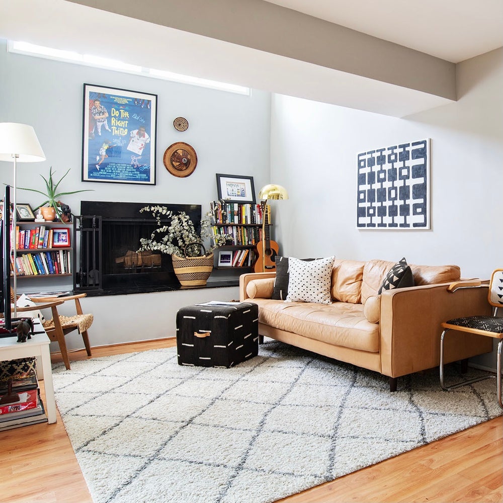 Handcrafted African mudcloth pillow in minimalist white for modern homes. Black and white seen here with African baskets and art with Moroccan rug on leather couch.